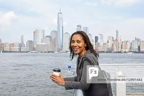 Geschäftsfrau macht Kaffeepause  im Hintergrund die Skyline von New York City