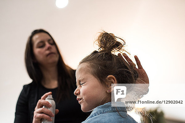 Mother tidying daughter's hair