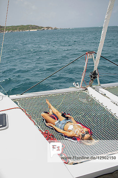 Junge Frau entspannt sich auf einem Segelboot  Britische Jungferninseln
