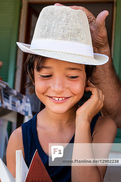 Grandfather placing hat on boy's head