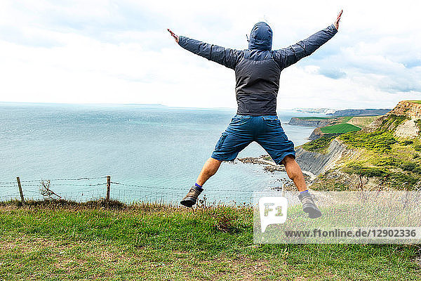 Mann springt auf Klippen auf dem Meer  Bournemouth  UK