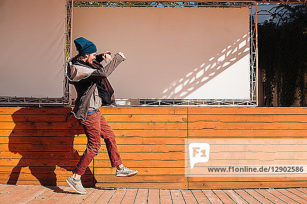 Hipster tanzen auf einer Holzterrasse neben der Bühne