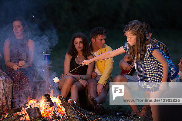 Mädchen toastet Marshmallow bei Lagerfeuer-Party im Park