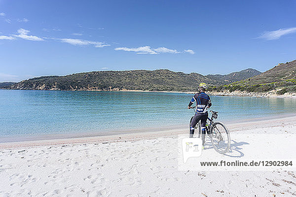 Cyclist on beach  Villasimius  Sardinia  Italy