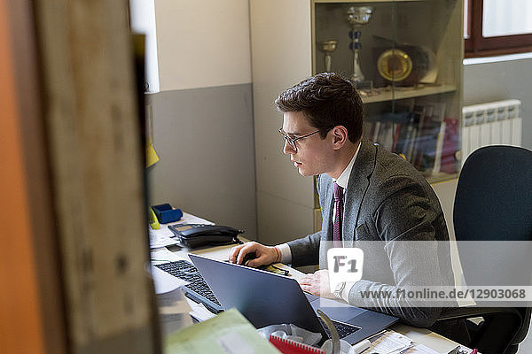 Mann benutzt Laptop und Desktop im Büro