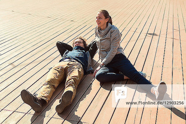 Couple relaxing on wooden decking