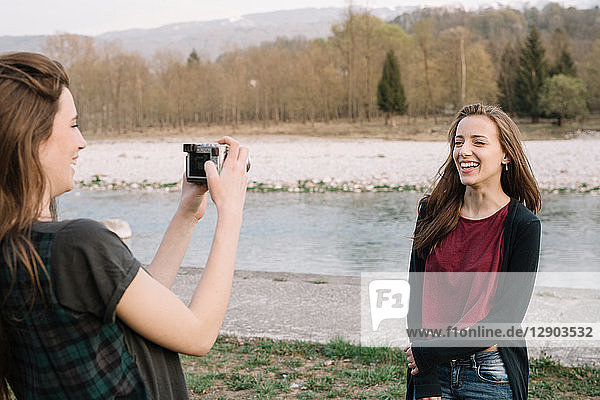 Freundinnen beim Fotografieren am Fluss  Belluno  Venetien  Italien