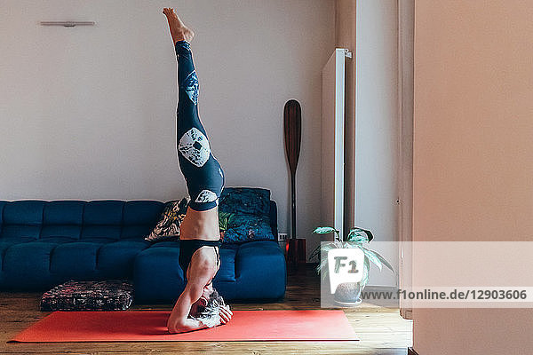 Frau praktiziert Yoga zu Hause