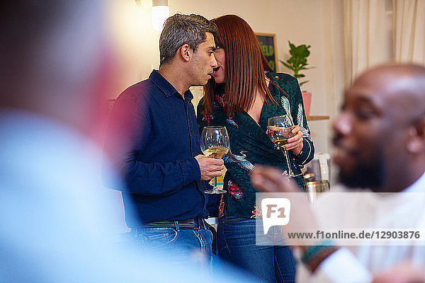 Friends talking,  couple whispering at dinner party