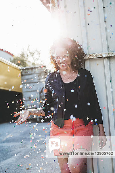 Laughing woman throwing confetti