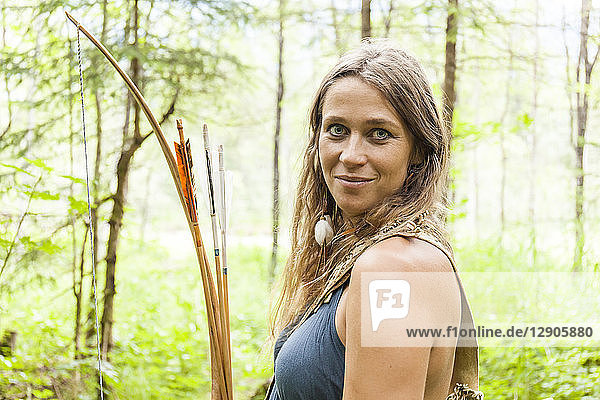 Portrait of smiling archeress in a forest