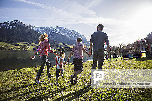 Austria  Tyrol  Walchsee  happy family walking at the lakeside