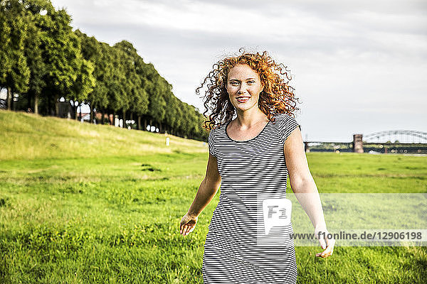Germany  Cologne  portrait of smiling young woman on meadow
