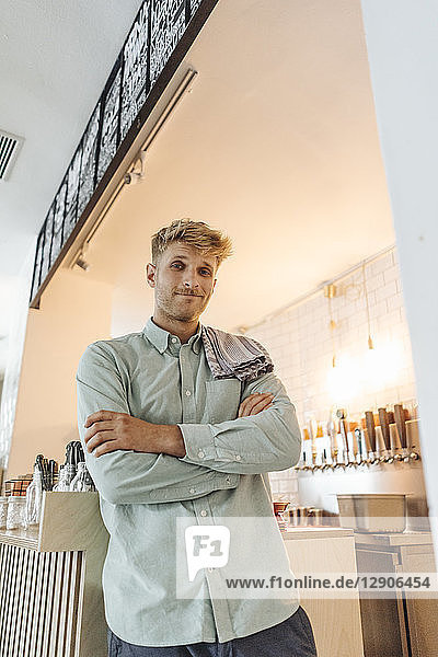 Young man working in his start-up cafe  portrait