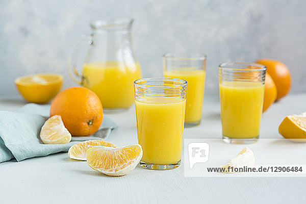 Glasses of freshly squeezed orange juice and orange slices