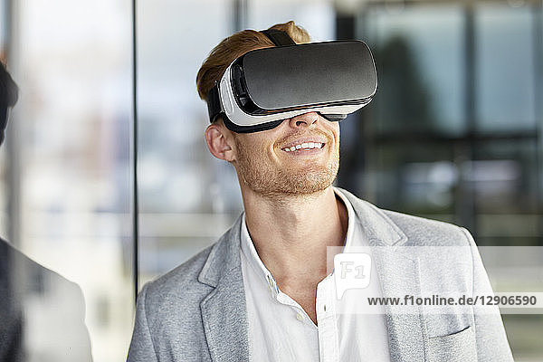 Smiling businessman wearing VR glasses