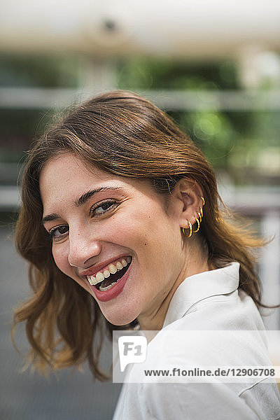 Young woman in greenhouse  laughing  portrait