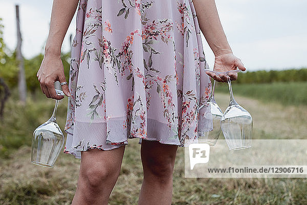 Woman carrying wine glasses at picnic