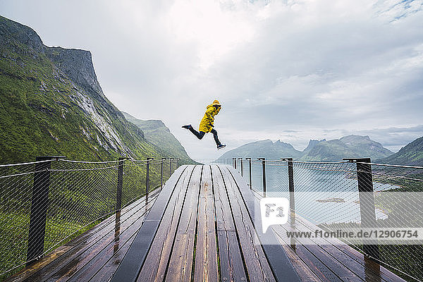 Norway  Senja island  man jumping on an observation deck at the coast