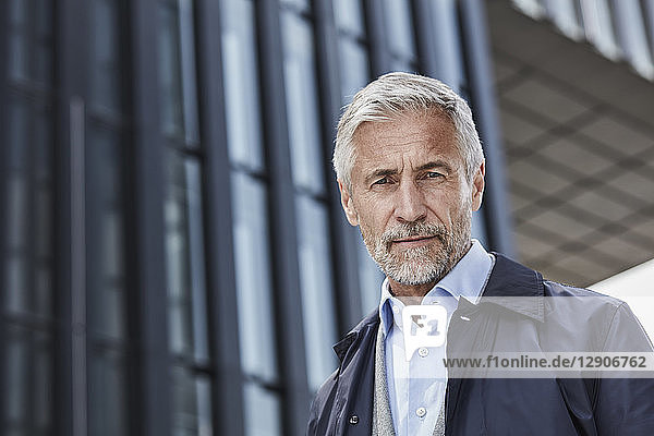 Portrait of mature businessman in front of an office building