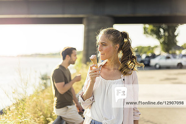 Couple eating ice cream in summer at the riverside