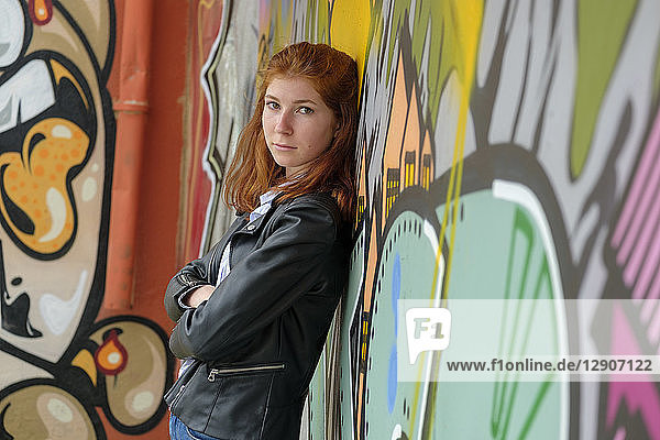 Italy  Finale Ligure  portrait of redheaded teenage girl leaning against mural
