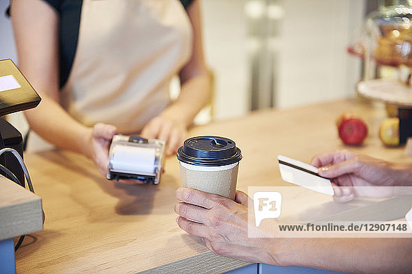 Close-up of customer paying by credit card in a cafe