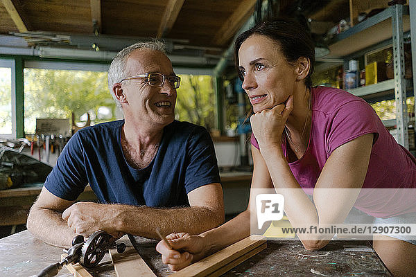 Smiling mature couple in workshop