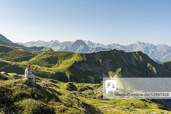 Germany  Bavaria  Oberstdorf  mother and little daughter on a hike in the mountains having a break looking at view