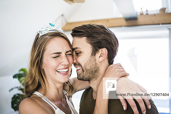 Happy couple at home with woman wearing tiara