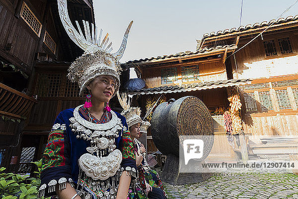 China  Guizhou  two young Miao women wearing traditional dresses and headdresses