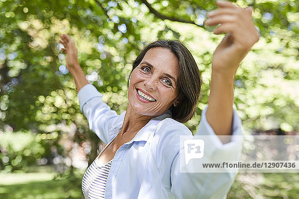 Portrait of smiling mature woman dancing in nature