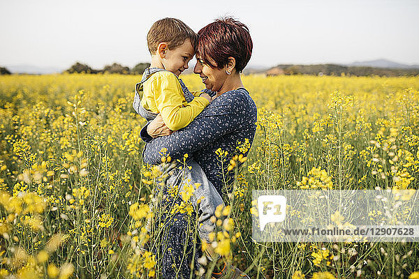 Mother standing with her little son in a rape field