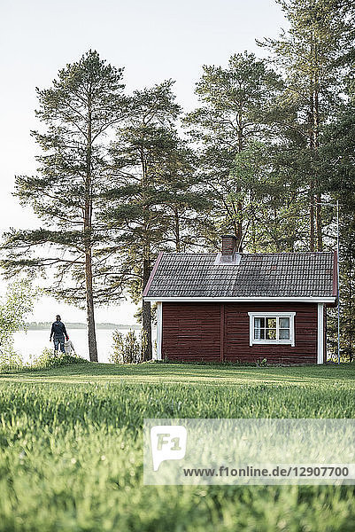 Finland  Kuopio  mother with daughter at a cottage by the lakeside in the countryside