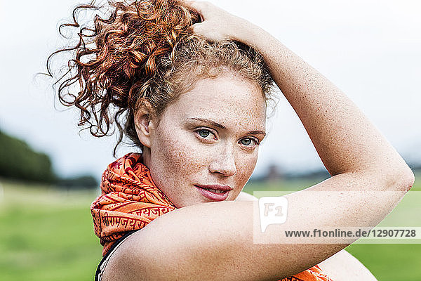 Portrait of freckled young woman with curly red hair