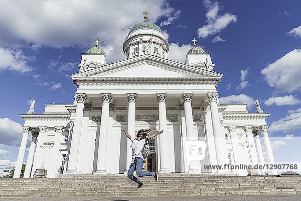 Finland  Helsinki  woman jumping in front of Helsinki Cathedral