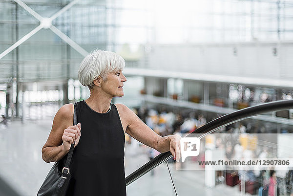Senior woman on escalator at the airport