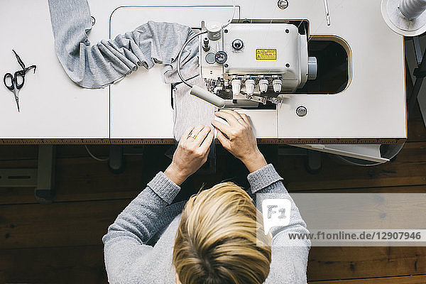Top view of woman using sewing machine