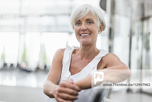 Portrait of smiling senior woman sitting in waiting area