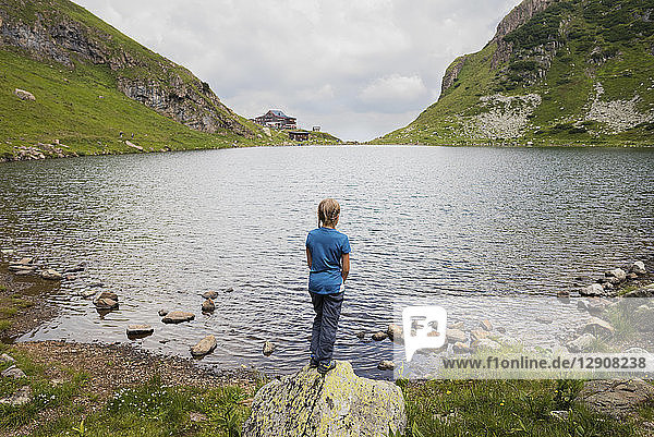 Austria  Tyrol  Fieberbrunn  Wildseeloder  girl standing at the shore of lake Wildsee