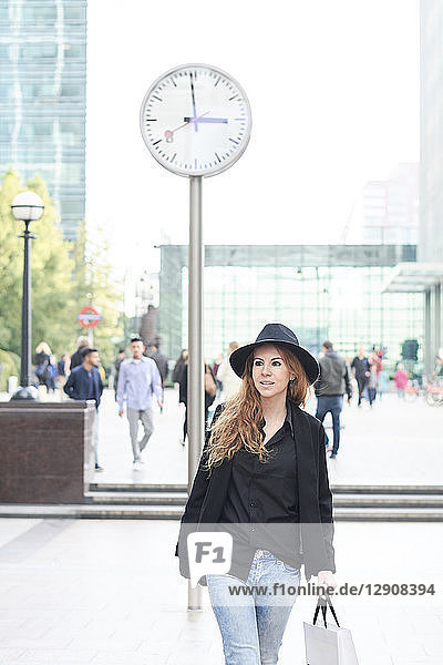 Mid adult woman wearing a hat going shopping in the city