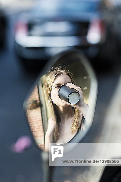 Young woman drinking coffee to go  mirror image