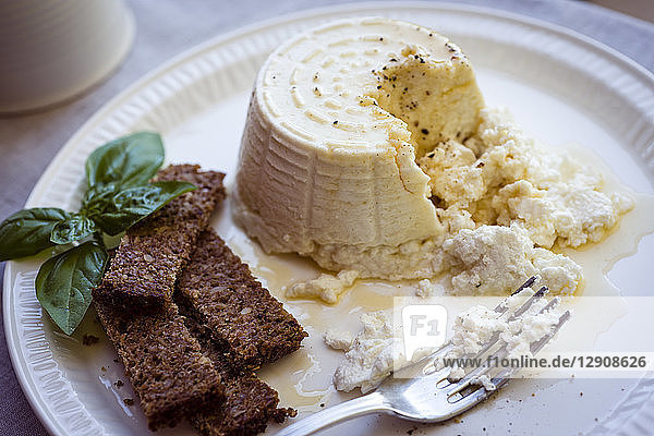 Ricotta cheese with honey and brown bread on plate