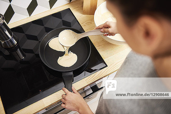 Young woman preparing pancakes
