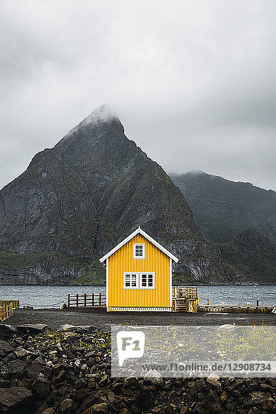Norway  Lofoten  remote yellow house at rocky coast