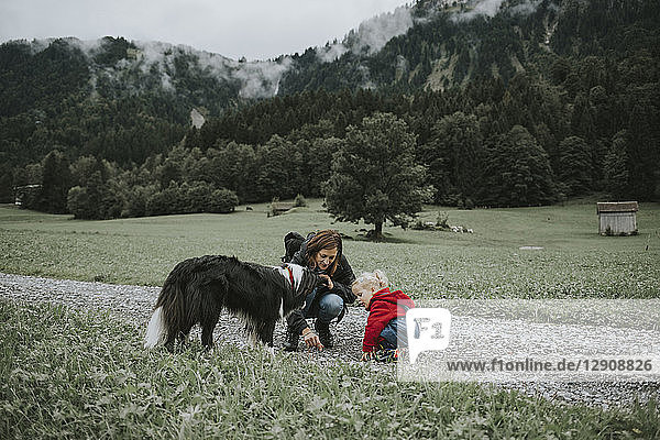 Austria  Vorarlberg  Mellau  mother and toddler with dog on a trip in the mountains