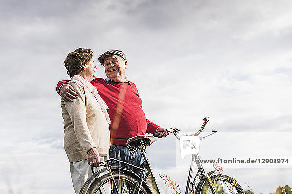 Happy senior couple with bicycles embracing