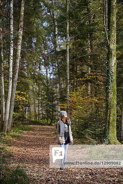 Redheaded teenage girl enjoying autumnal forest