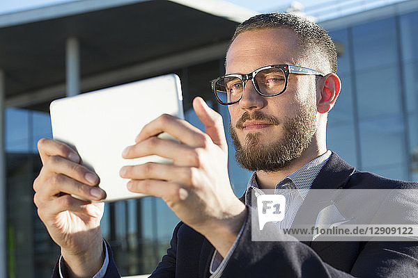 Businessman holding a tablet in the city