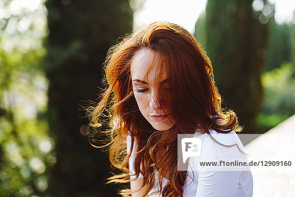 Portrait of redheaded woman at backlight